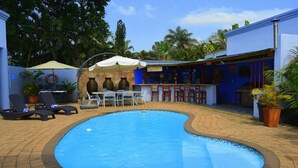A swimming pool with lounge chairs and a bar area. - Turtle Bay Lodge (St. Lucia)