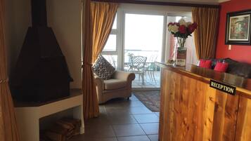 A reception area with a wooden counter, a sofa, and a chair.