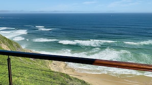 Une vue sur la côte, avec une plage, des vagues et un ciel dégagé.