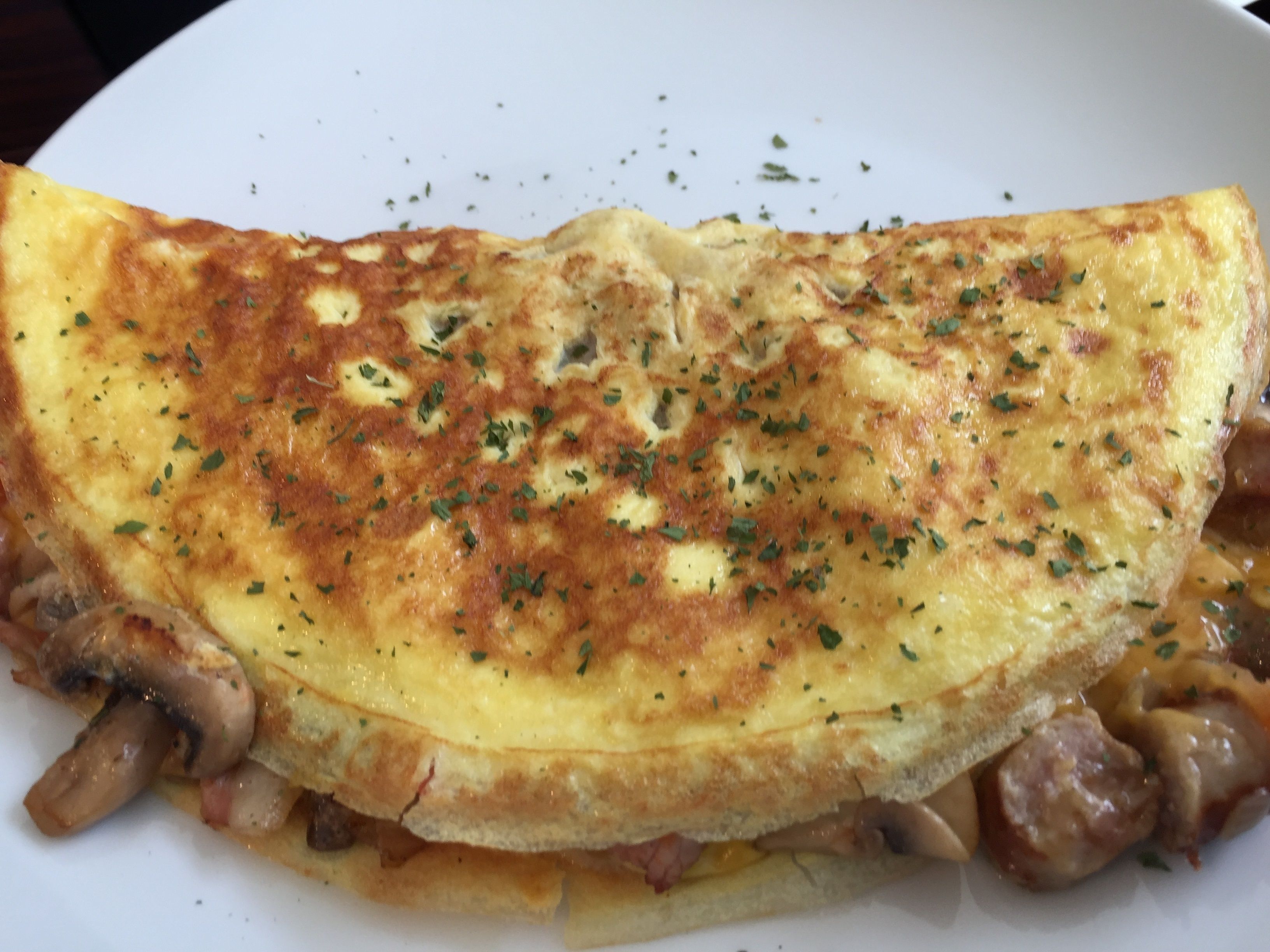 Un plato con una tortilla enrollada, adornada con hierbas.