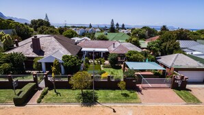 A residential area with houses, a small pond, and a clear view of the ocean. - Brown Jug Guest House (Hermanus)