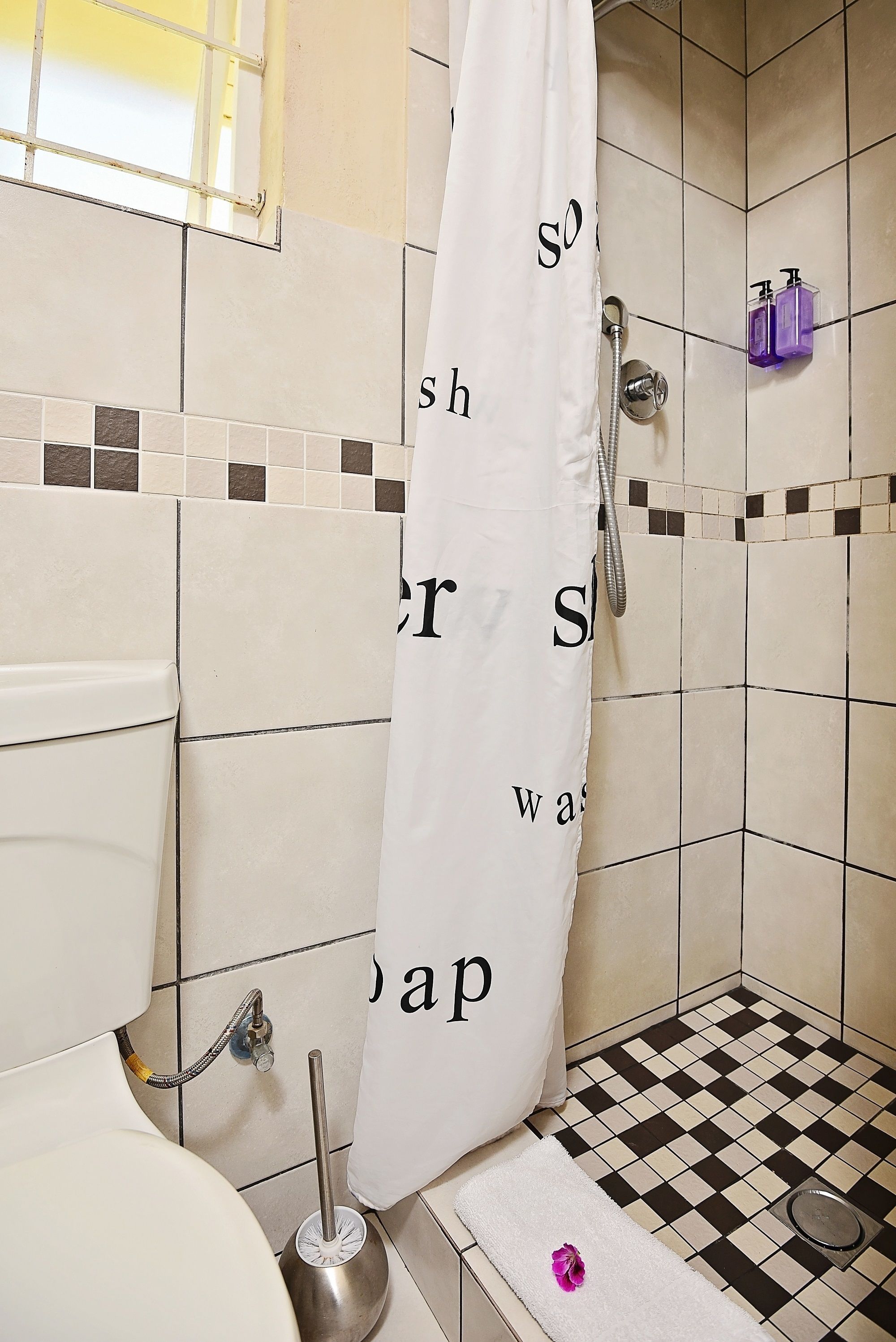 A bathroom with a shower, toilet, and sink.