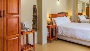 A bedroom with a large bed, wooden wardrobe, bedside table with lamp, and a mirror. - Sabie Retreats Guest House (Sabie)