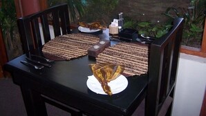 Una mesa para comer con una silla de madera, un adorno y una botella.