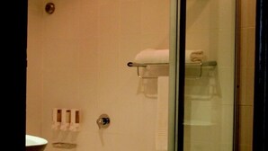 Un baño con bañera, cabina de ducha de cristal y un inodoro.
