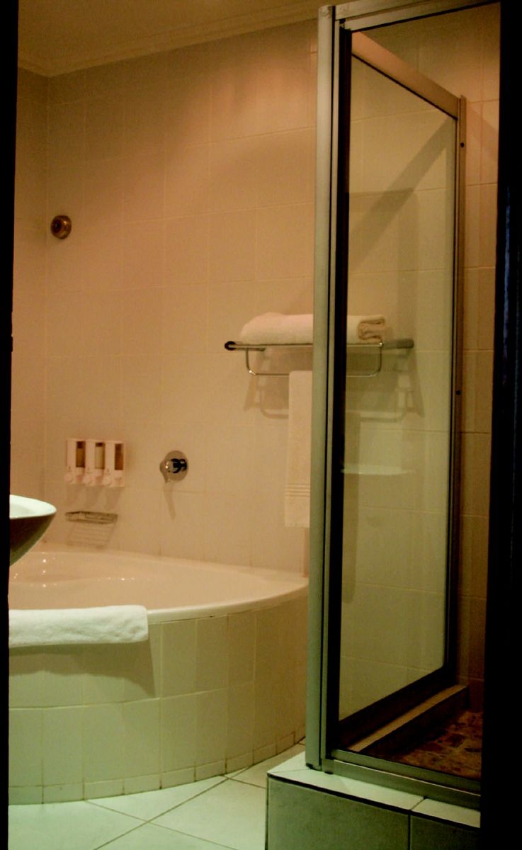 Un baño con bañera, cabina de ducha de cristal y un inodoro.