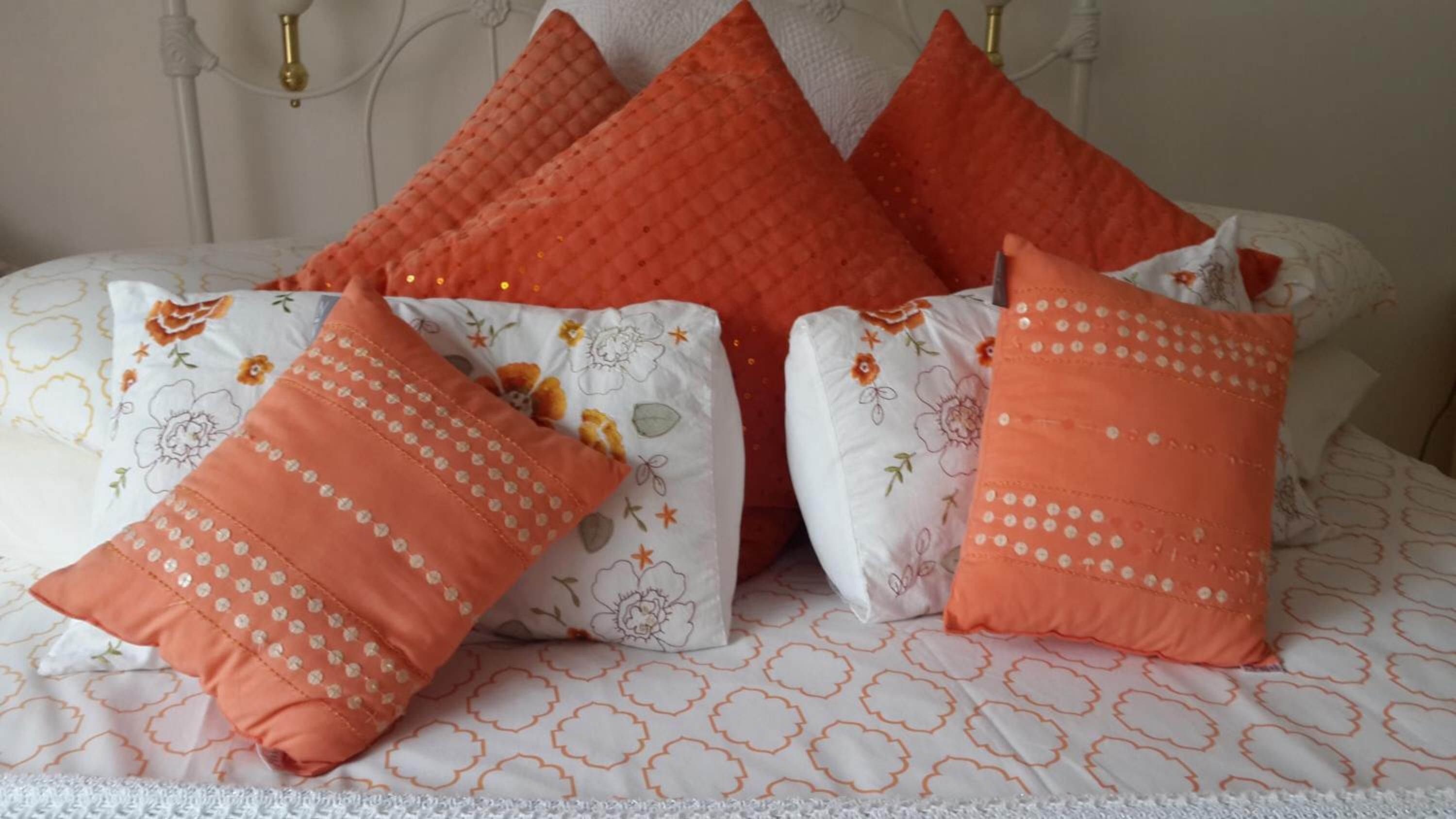 Un lit avec plusieurs oreillers et une couvre-lit à motifs.