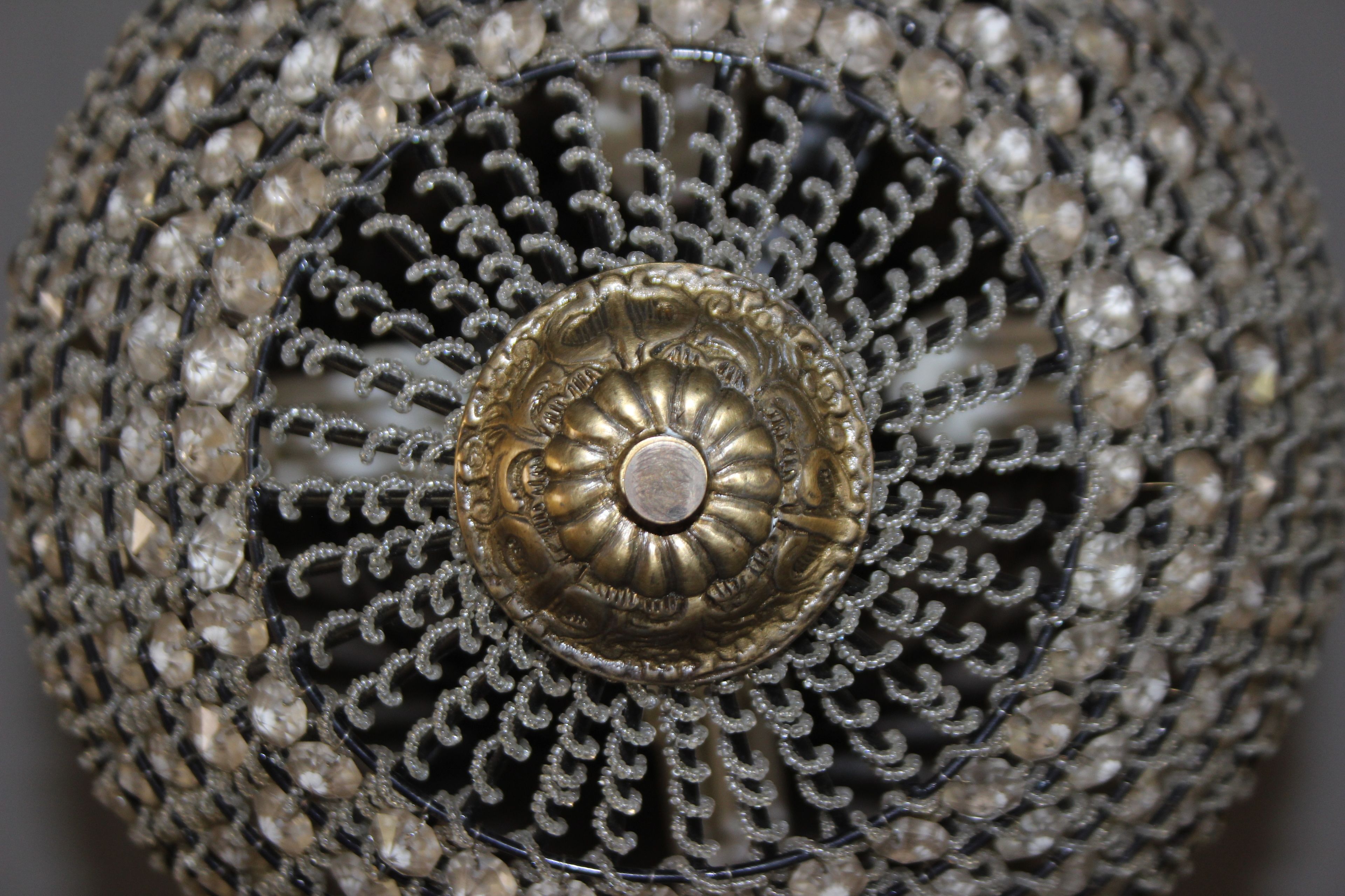 A close-up of a decorative metal object with intricate patterns and a central circular design.