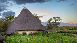 Une hutte au toit de chaume, entourée d’une végétation luxuriante.