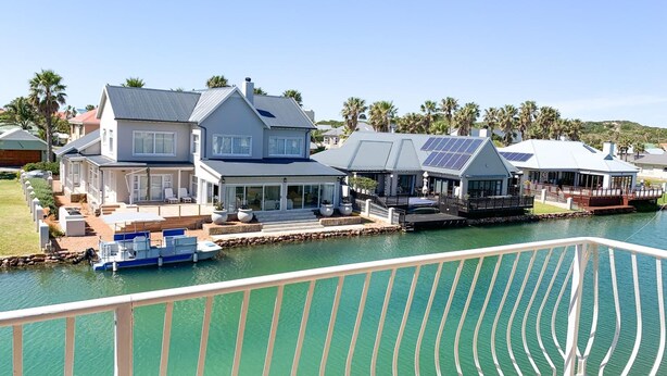 A waterfront property with multiple houses, a dock, and a pool. - Marina Martinique B and B (Jeffreys Bay)