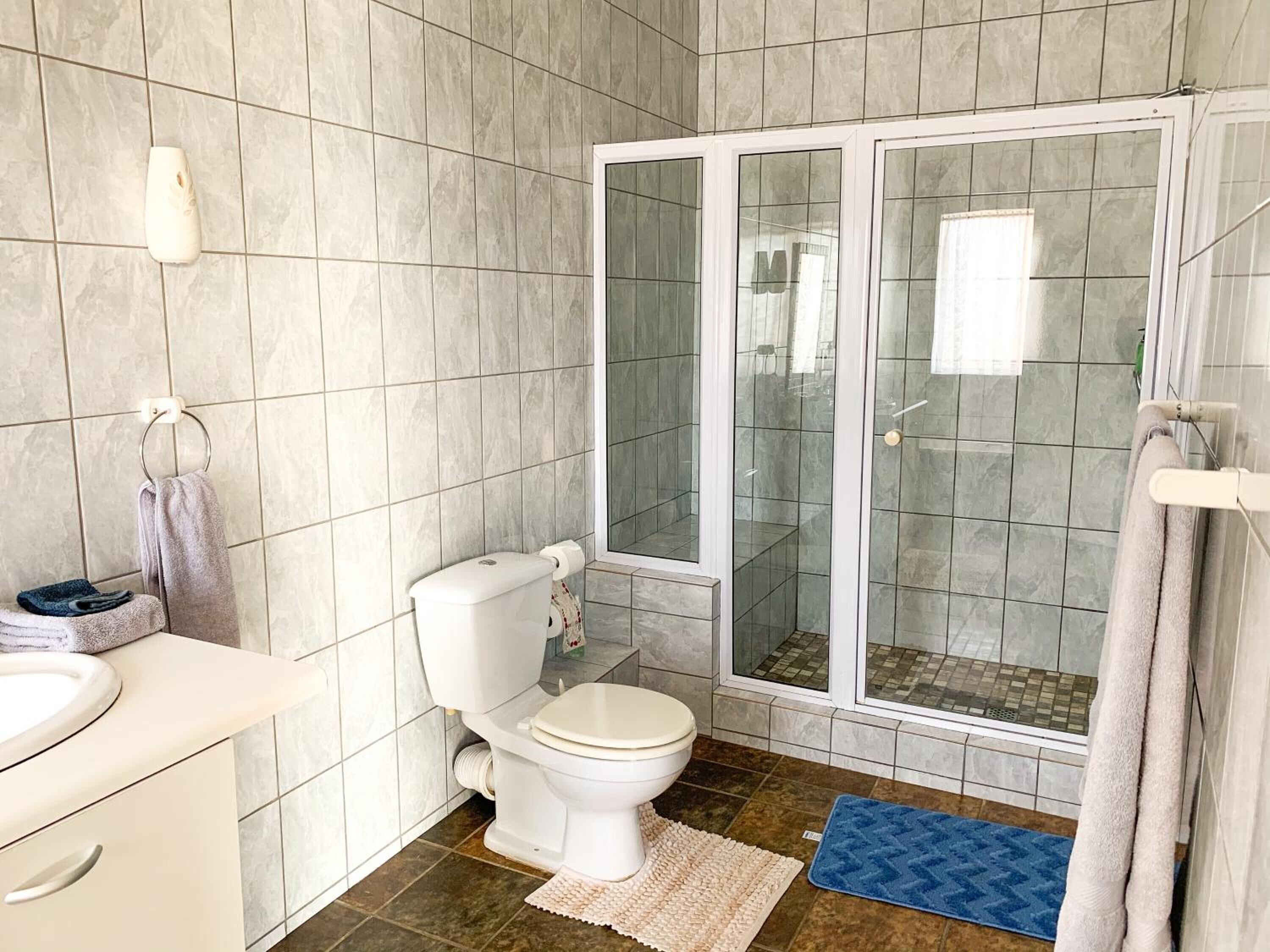 A bathroom with a toilet, sink, and shower area.