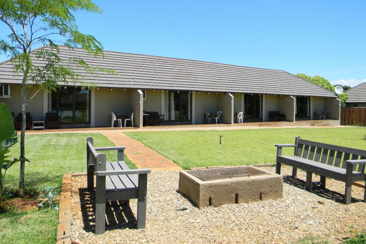 A building with a covered patio area, outdoor seating, and a fire pit.