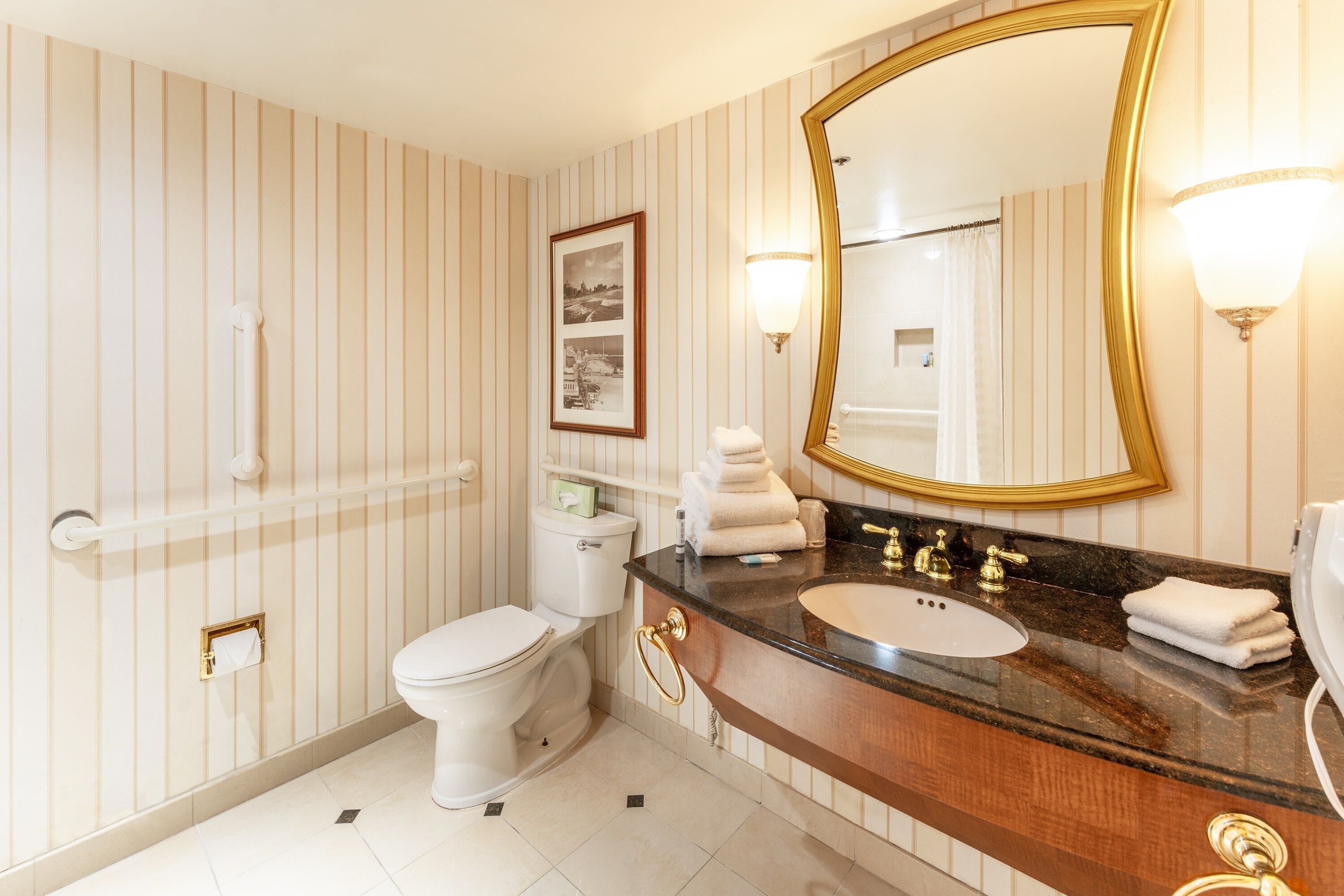 A bathroom with a toilet, sink, and mirror.