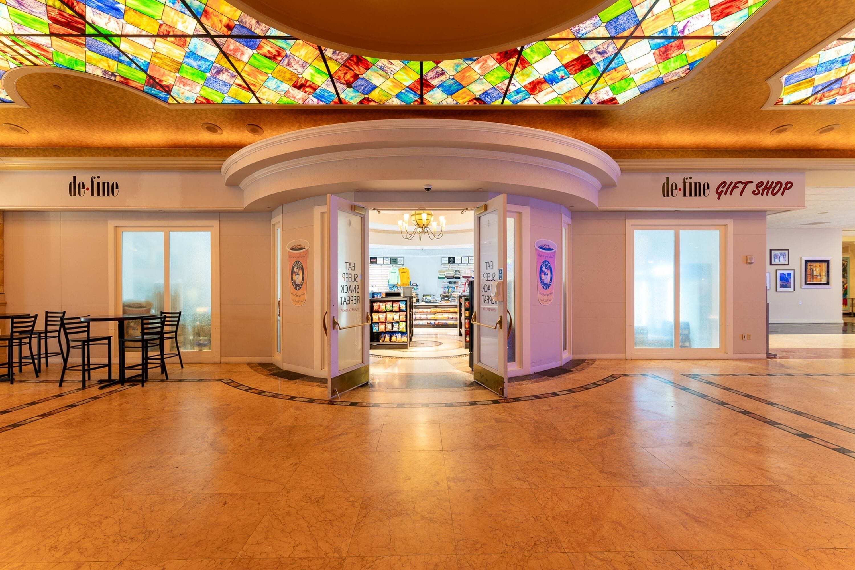 Un hall d’entrée spacieux avec un plafond en vitraux, une boutique de souvenirs et un espace détente.