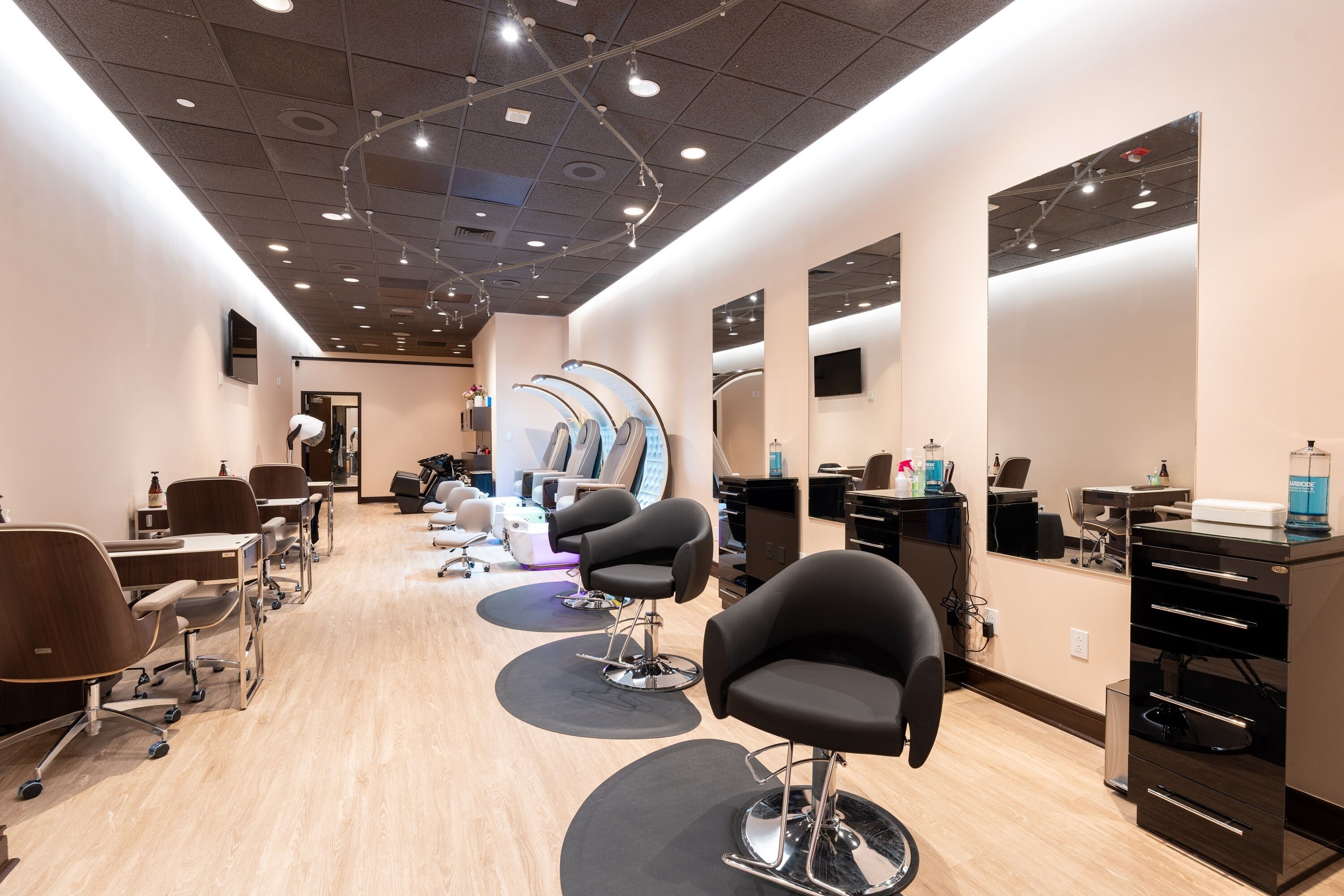 A salon with multiple hairdressing stations, each equipped with a chair and a mirror.