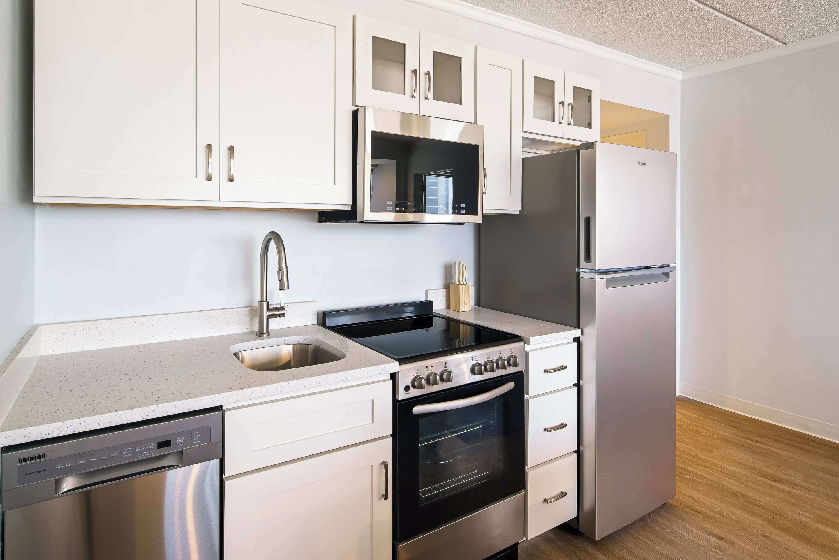 Cocina compacta con lavavajillas, horno, microondas y refrigerador.