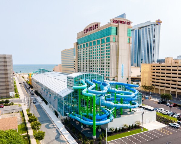 Un hôtel doté d’un grand parc aquatique, offrant une vue sur l’océan et s’inscrivant dans un paysage urbain caractérisé par de nombreux immeubles de grande hauteur.