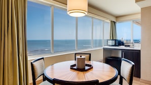 A hotel room with a round dining table, two chairs, a microwave, and a view of the ocean. - Showboat Hotel Atlantic City (Atlantic City)