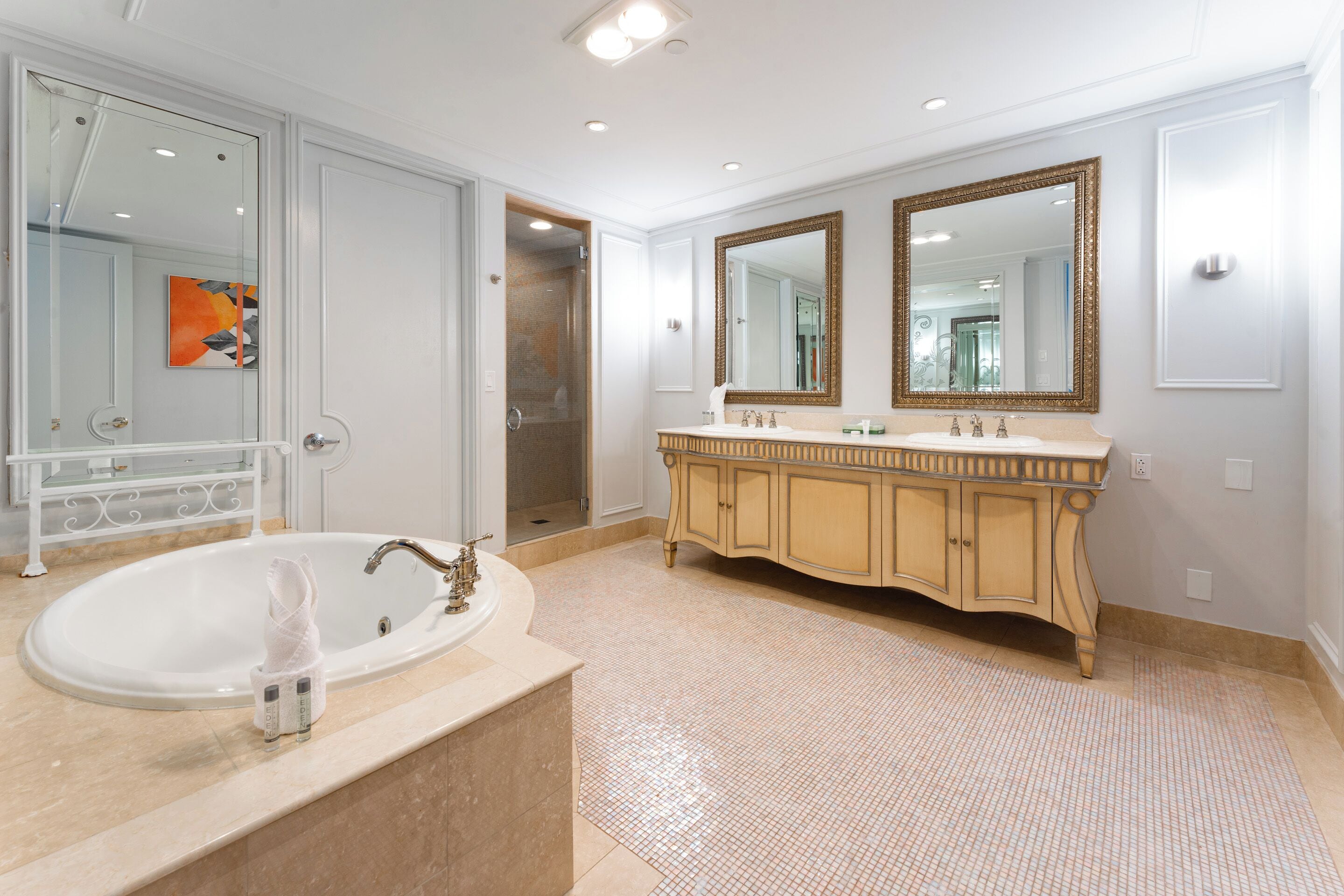 Ein geräumiges Badezimmer mit einer großen Badewanne, einem Doppelwaschtisch mit zwei Waschbecken und einer begehbaren Dusche.