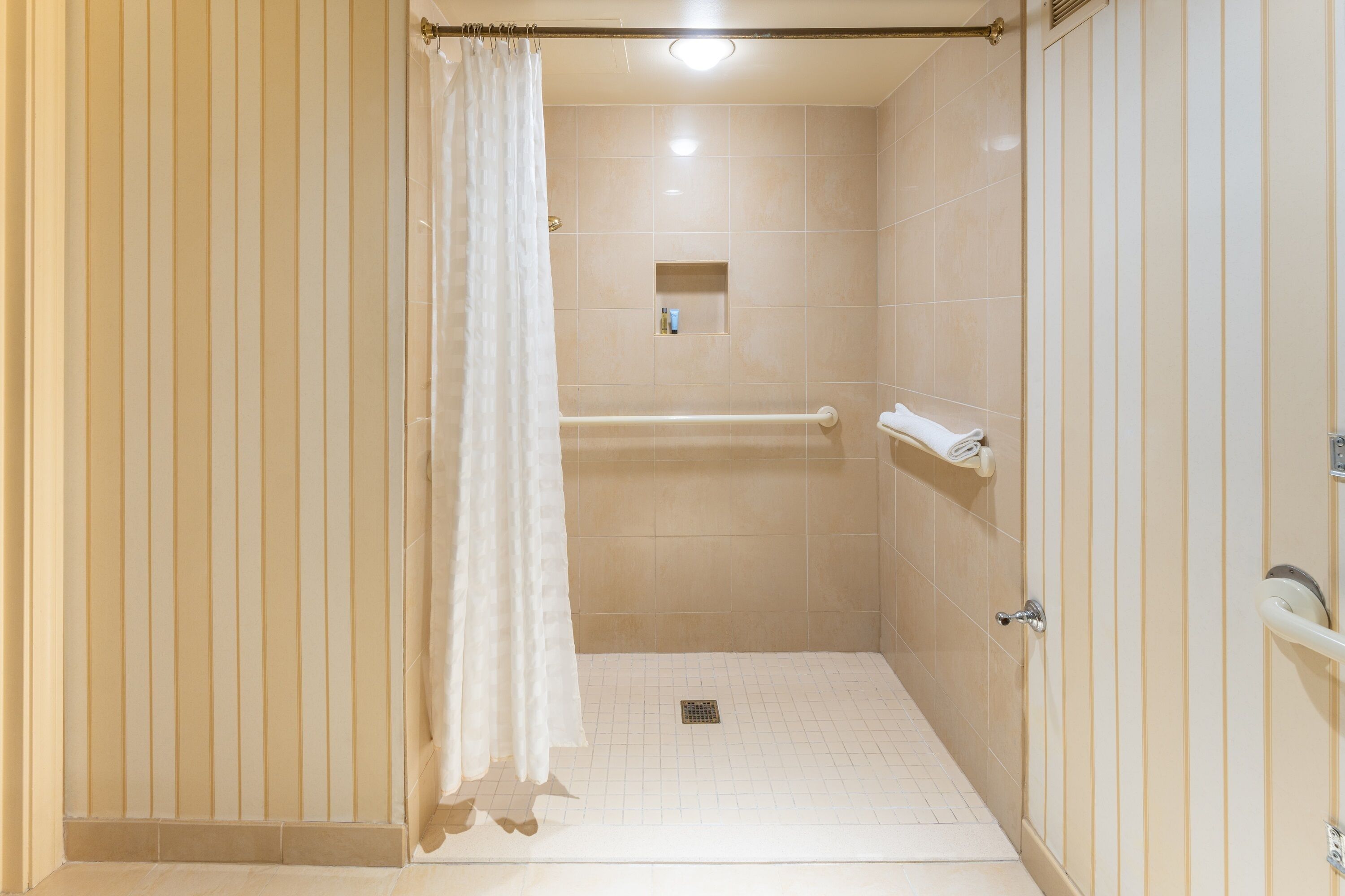 A bathroom with a shower, a toilet, and a sink.