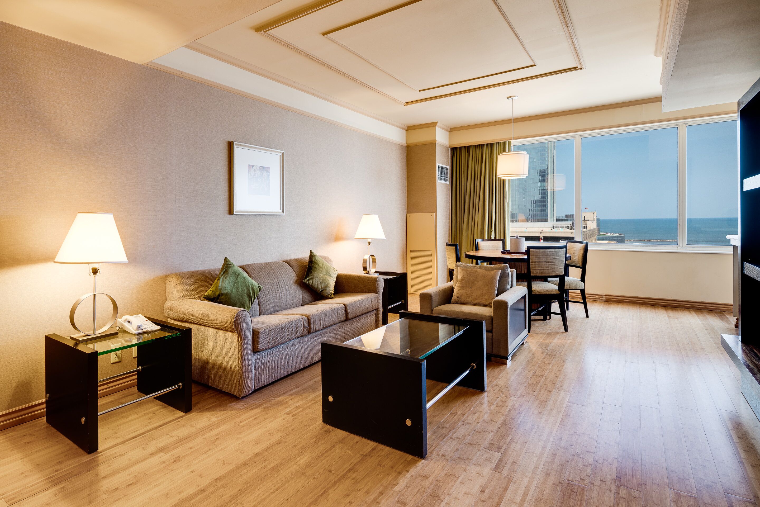 Une chambre d’hôtel avec un canapé, des fauteuils, une table basse et une vue sur l’océan.
