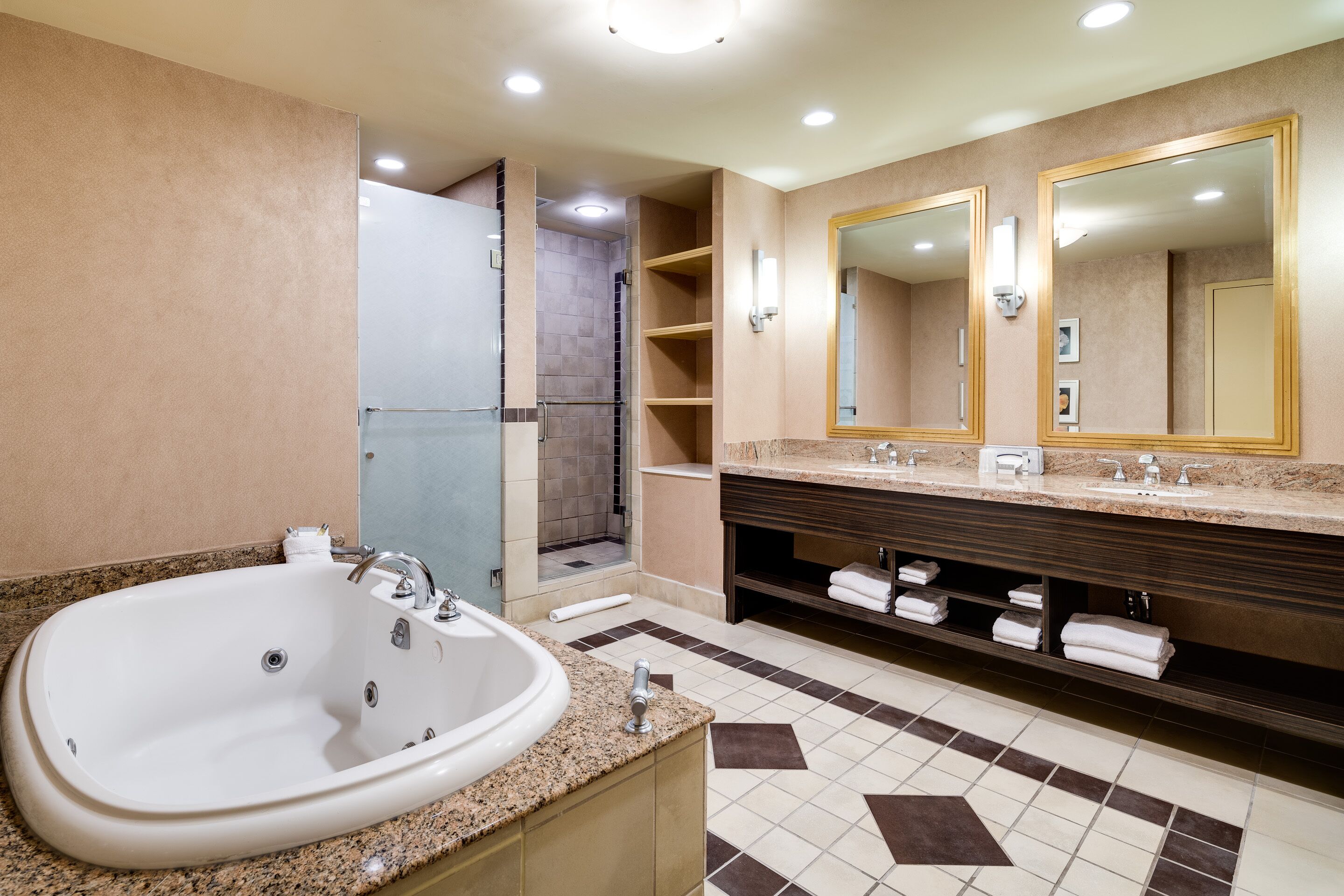 A modern bathroom with a large bathtub, double sinks, and a walk-in shower.