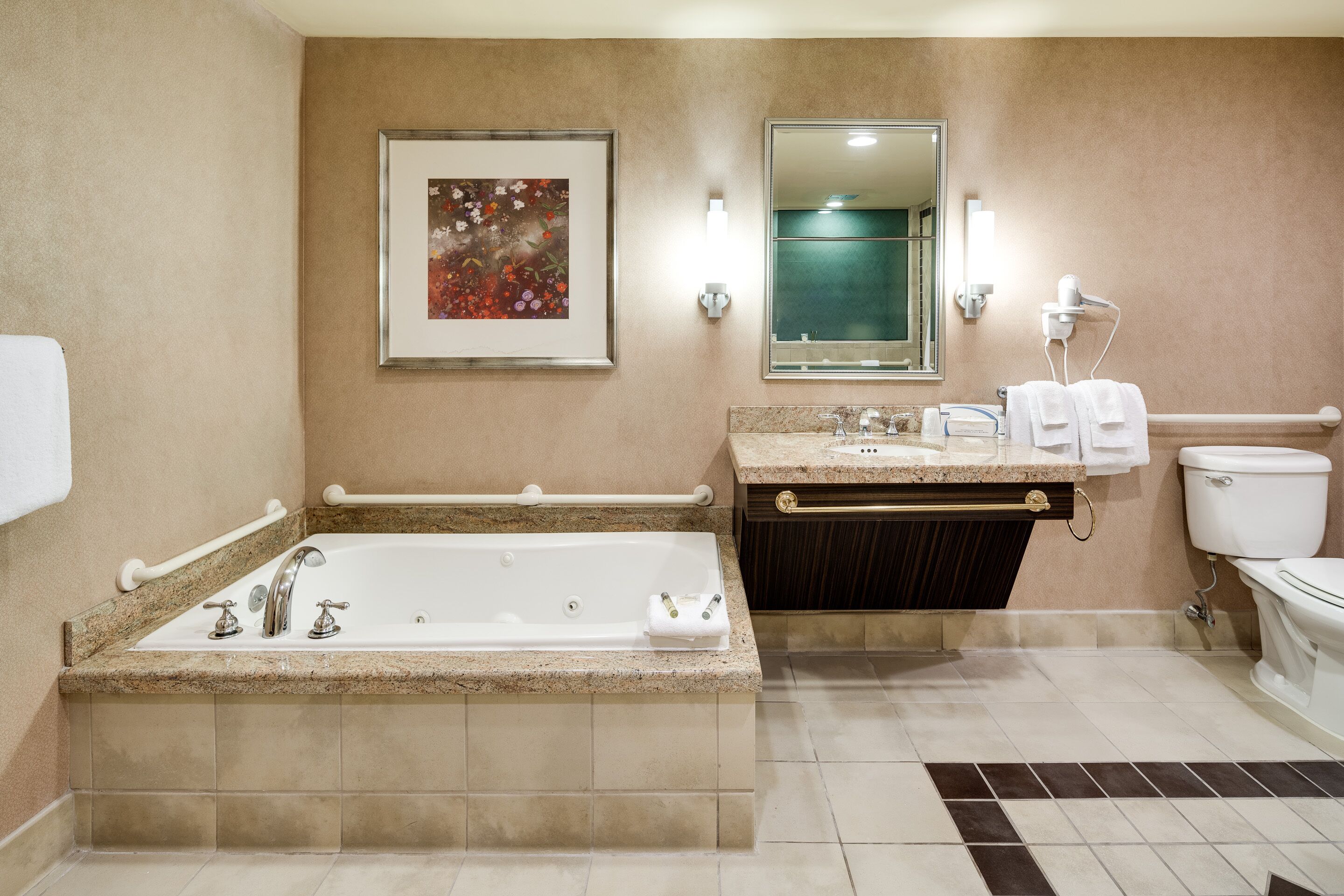 Une salle de bain avec une grande baignoire, un meuble-lavabo avec un miroir et des toilettes.