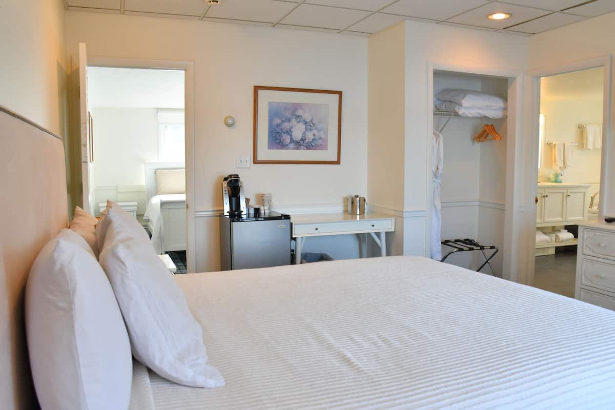 Ein Hotelzimmer mit Bett, Schreibtisch, Kaffeemaschine, Kleiderschrank und Bad.
