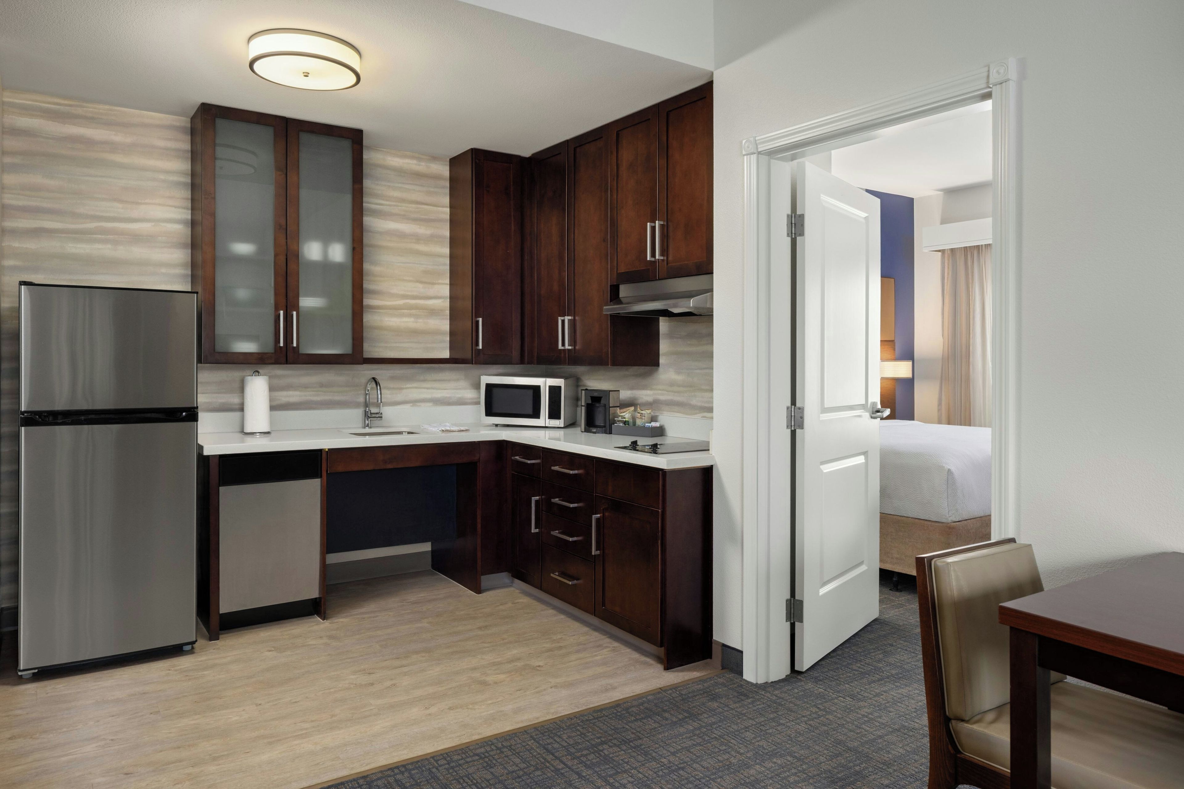A modern kitchen with a refrigerator, microwave, and cabinets.