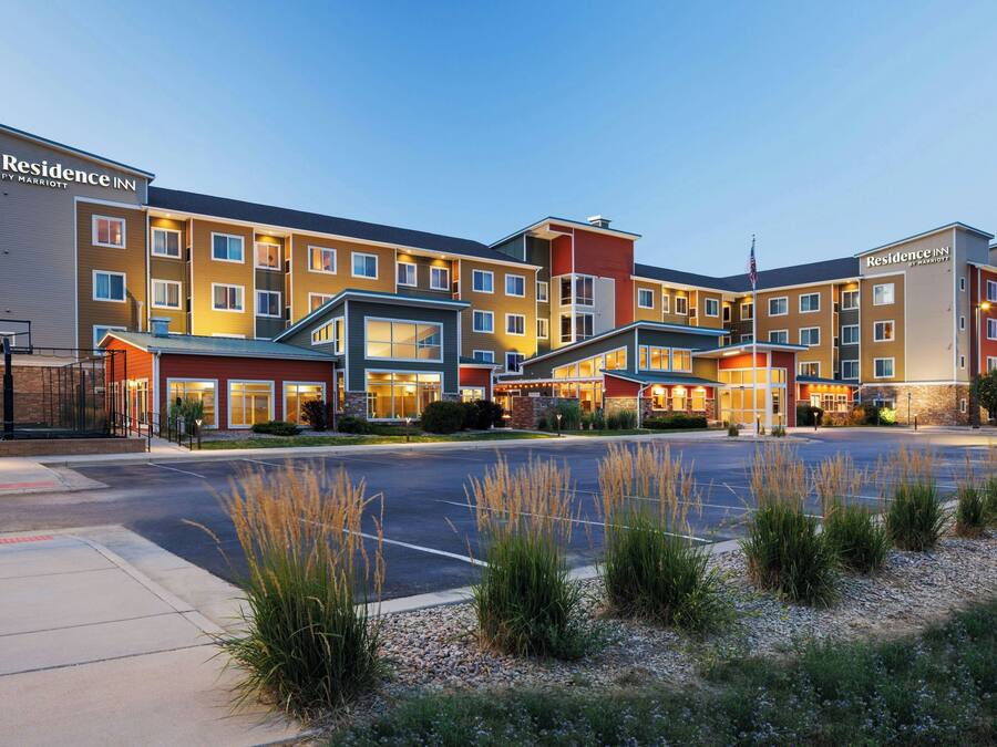 A multi-story hotel with a modern design, featuring a central courtyard and a parking lot.