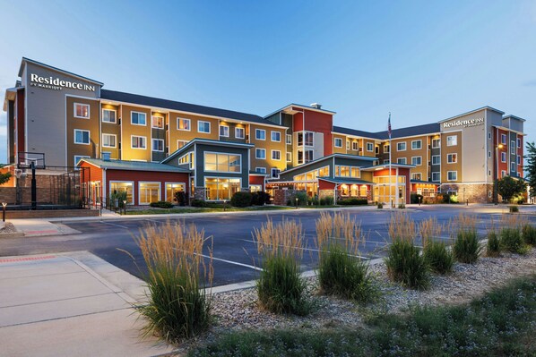 A multi-story hotel with a modern design, featuring a central courtyard and a parking lot.