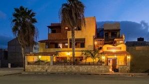 A two-story building with a stone facade, multiple balconies, and a lit entrance. - Sakaroule Bed & Breakfast (Sal)