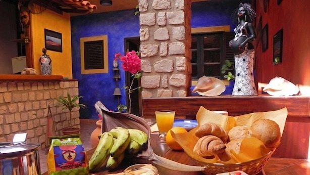 A breakfast setup with bananas, croissants, and a bottle of orange juice on a wooden table. - Sakaroule Bed & Breakfast (Sal)
