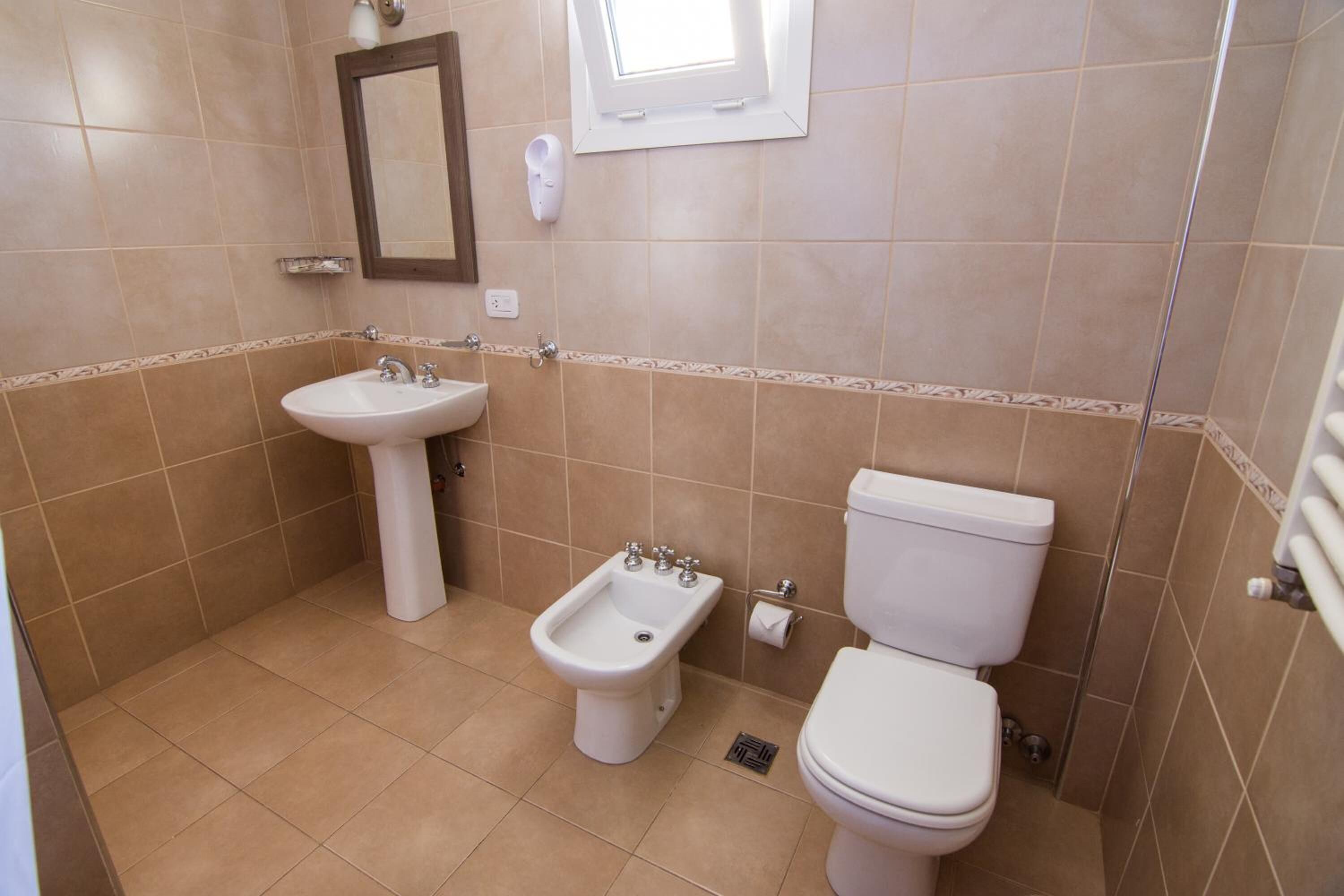 A bathroom with a sink, bidet, and toilet.