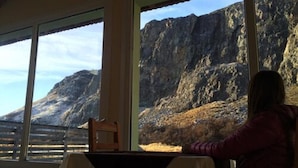 A room with large windows offering a view of a mountainous landscape. - Vertical Lodge (El Chalten)