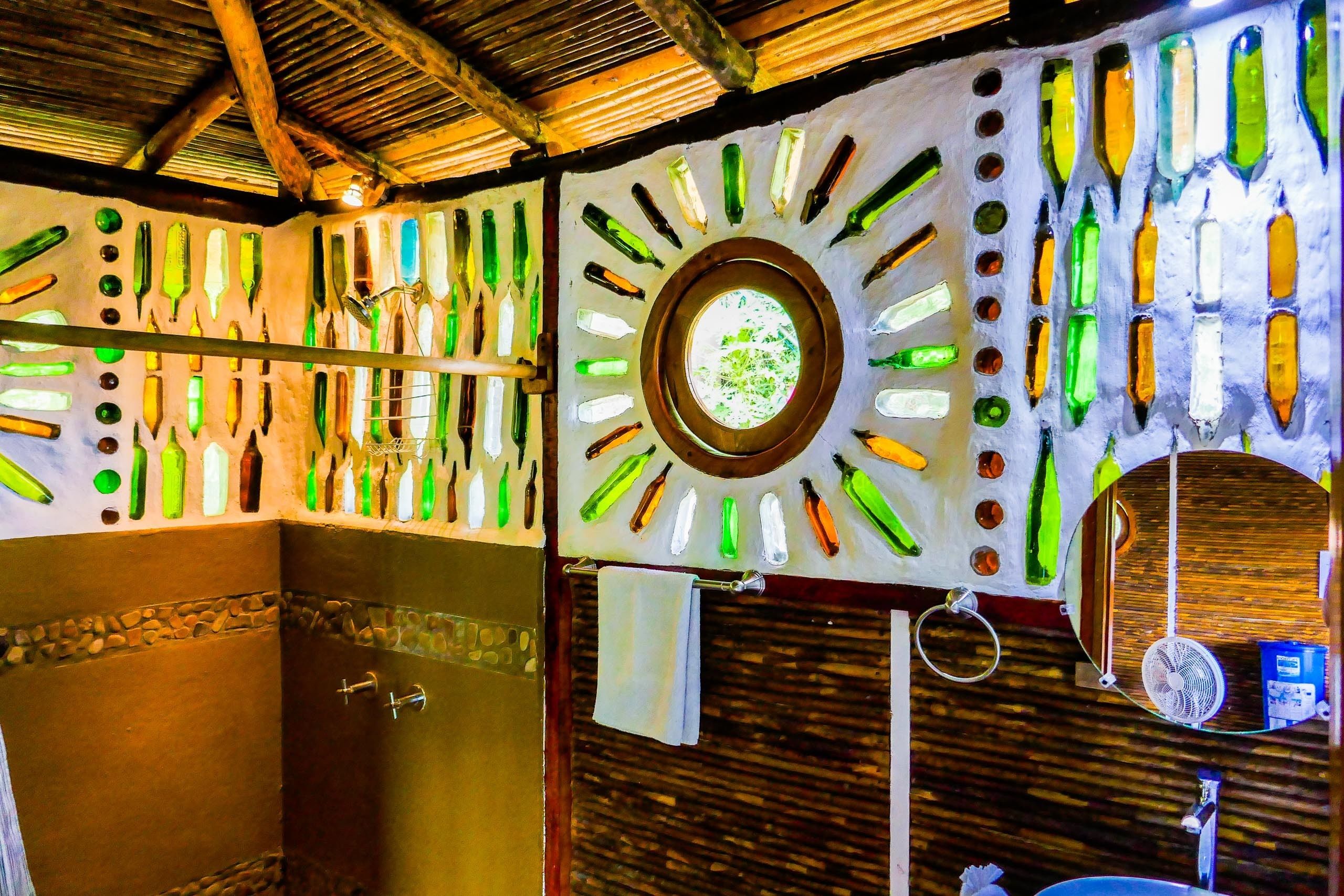 Casa de banho com um design de parede único, destacando garrafas de formas variadas.