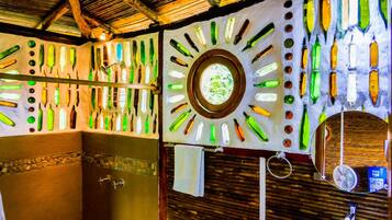 Casa de banho com um design de parede único, destacando garrafas de formas variadas.