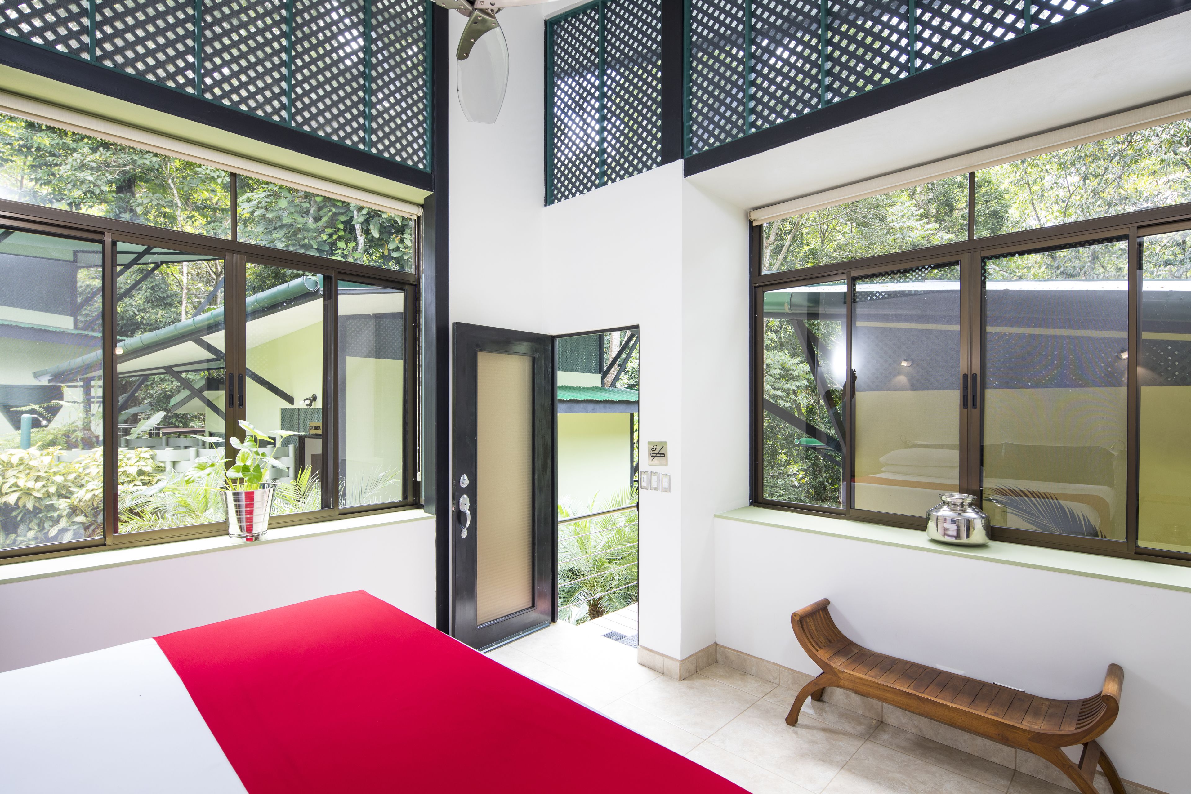 Una habitación con ventanas amplias, un banco y una puerta que da al exterior.