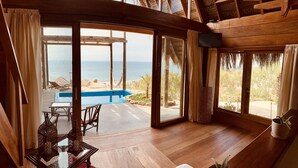 A wooden interior with a glass door leading to a pool and beach view. - La Playa (Los Organos)