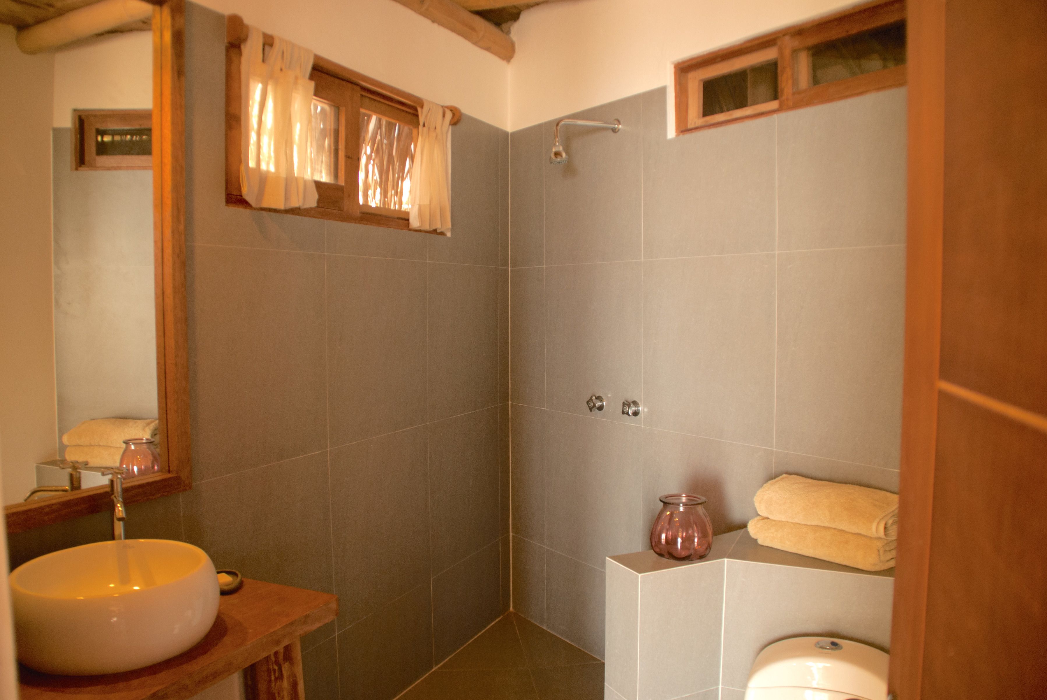 Un baño con un lavamanos amplio, ducha y retrete.