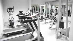 A gym with treadmills, elliptical machines, and weightlifting equipment. - VU'Z Hotel Apt (Blat)