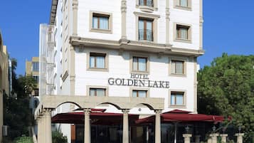 Hotel Golden Lake features a classic, symmetrical facade with multiple windows and a balcony on upper floors.