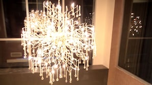 A modern interior with a decorative chandelier, a fireplace, and a view of the outside through a window. - Edis Premier Hotel (Adana)