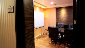 A conference room with a whiteboard, a wooden panel wall, and four black office chairs. - Edis Premier Hotel (Adana)