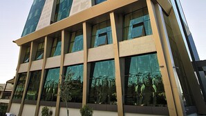 A modern high-rise building with reflective glass windows, a beige facade, and a corner entrance. - Edis Premier Hotel (Adana)