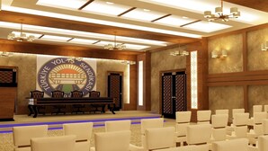 A conference room with a stage, a reception desk, and rows of chairs. - Yol Is Holiday Adana (Adana)