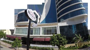 A modern building with a sign for 'Cafe Holiday' and 'Patisserie & Bistro'. - Yol Is Holiday Adana (Adana)