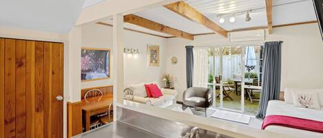 A modern kitchen with a stainless steel sink and wooden ceiling beams.