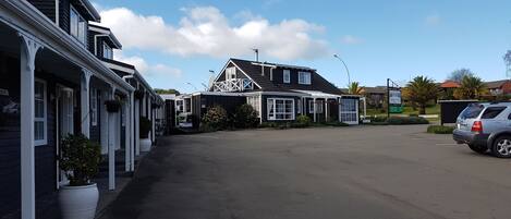A row of single-story buildings with a central building featuring a porch and a satellite dish.