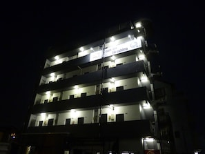 A multi-story hotel with illuminated signage, balconies, and a modern architectural design.